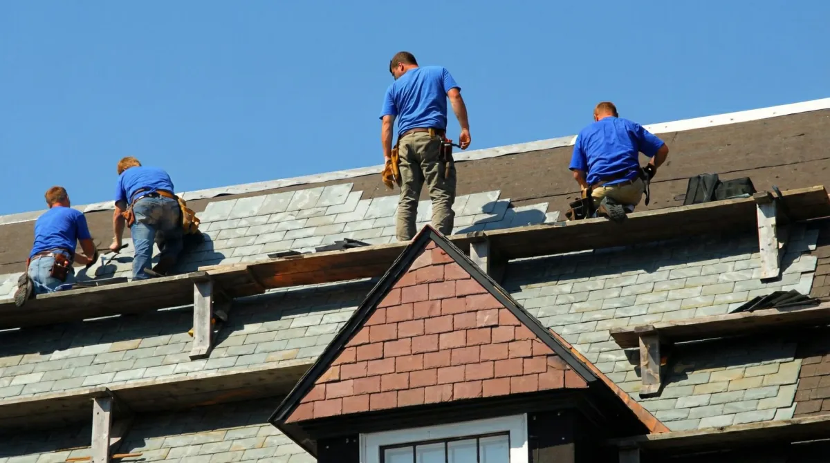 Roof replacement in progress with a team of professional contractors installing new shingles on a residential home in Birmingham, AL